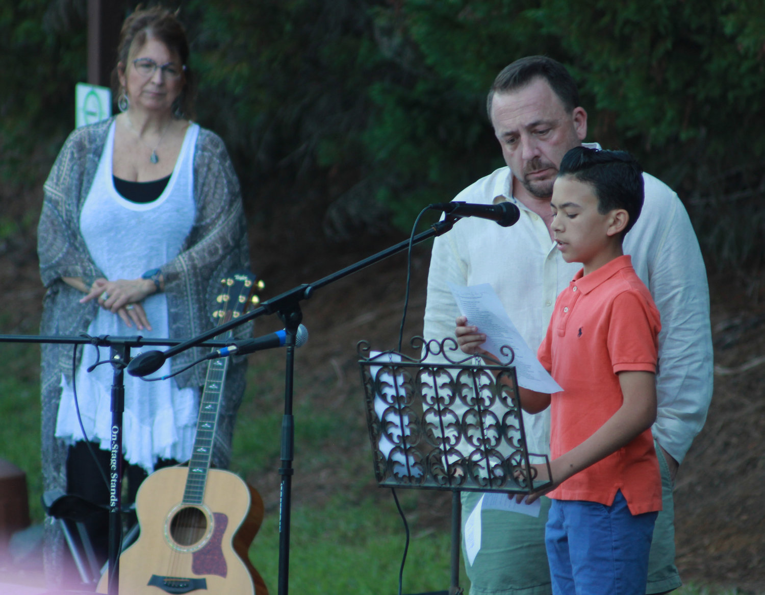 James Vose, center, and his son Waylon Vose (14), right, volunteer to read aloud the list of mass shootings that have occured in the United States during the Chatham County vigil for recent mass shootings on Sunday, May 29, in Pittsboro. The long list detailed the places where the shootings occurred and the number of victims.